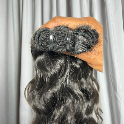 Close up of weft on wavy Raw Indian hair extensions